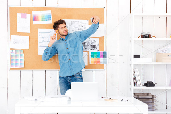 Businessman making selfie while standing in front of office board Stock photo © deandrobot