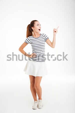 Happy inspired young woman pointing up and having an idea Stock photo © deandrobot