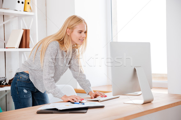 Mosolyog fiatal üzletasszony áll néz számítógép Stock fotó © deandrobot