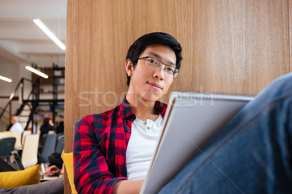 Asian student studying in university library sitting on sofa Stock photo © deandrobot