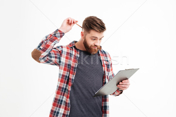 Thoughtful man in plaid shirt scratching his head by hand Stock photo © deandrobot