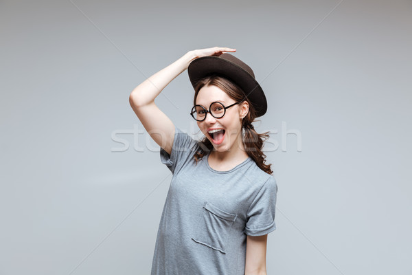 Happy Female nerd holding for her hat Stock photo © deandrobot