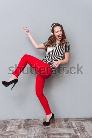Vertical image of Hipster jumping in studio Stock photo © deandrobot