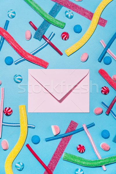 Top view of colorful sugar candies and lollies with envelope Stock photo © deandrobot