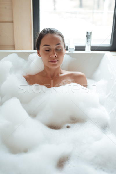 Relaxed woman with closed eyes sitting and resting in bathtub Stock photo © deandrobot
