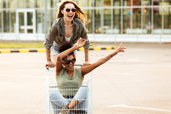 Two young happy women in sunglasses having fun Stock photo © deandrobot