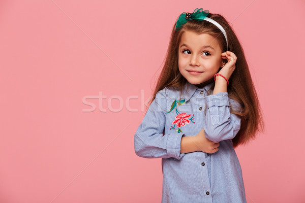 Portrait of cute schoolgirl 5-6 years touching her long auburn h Stock photo © deandrobot