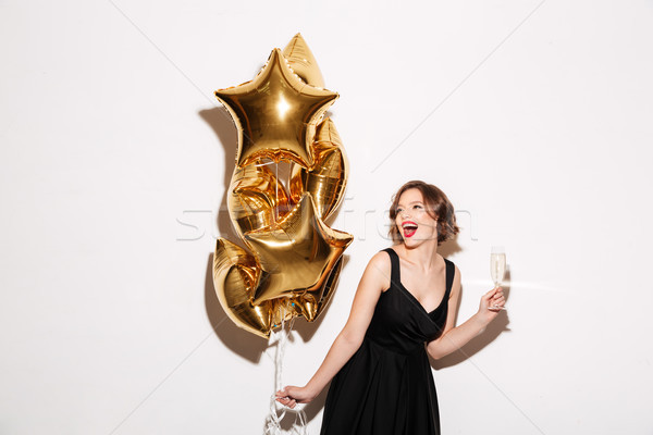 Portrait of a cheery girl dressed in black dress Stock photo © deandrobot