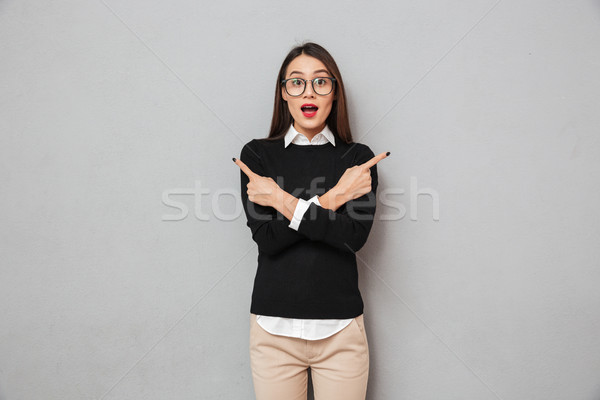 Surprised asian woman in business clothes and eyeglasses Stock photo © deandrobot