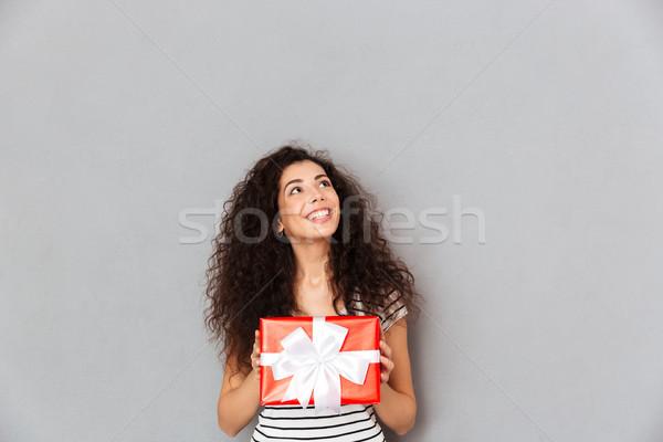 Smiling pretty woman holding gift-wrapped box feeling pleasure t Stock photo © deandrobot