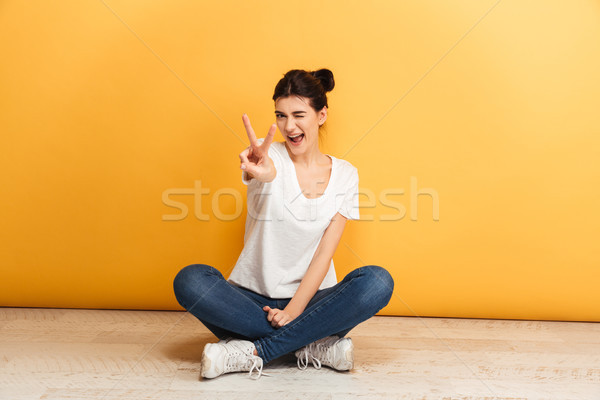 Portrait souriant jeune femme séance jambes croisées étage [[stock_photo]] © deandrobot