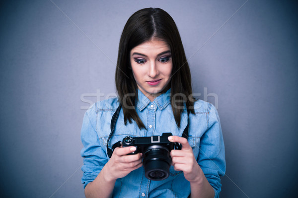 Surprised young woman looking on camera screen Stock photo © deandrobot