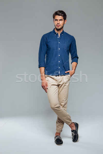 Portrait of a casual man standing with hand in pocket Stock photo © deandrobot
