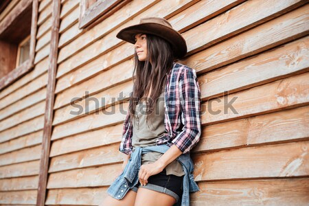 Cheerful attractive young woman cowgirl standing and smiling Stock photo © deandrobot