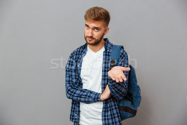Portrait of a hipster man standing with open palm Stock photo © deandrobot