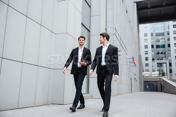 Two businessmen walking and talking in the city Stock photo © deandrobot