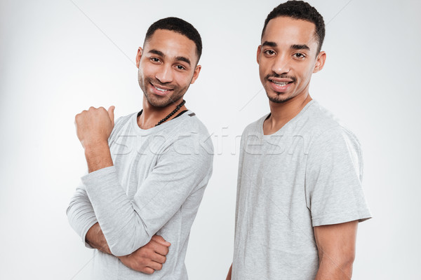 Happy two african men posing over white background Stock photo © deandrobot