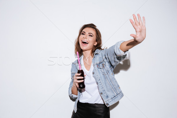 Cheerful lady drinking aerated sweet water. Stock photo © deandrobot