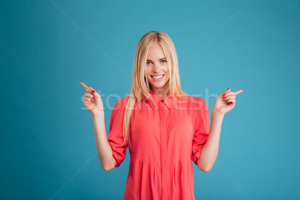 Glimlachend charmant jonge vrouw wijzend twee vingers Stockfoto © deandrobot