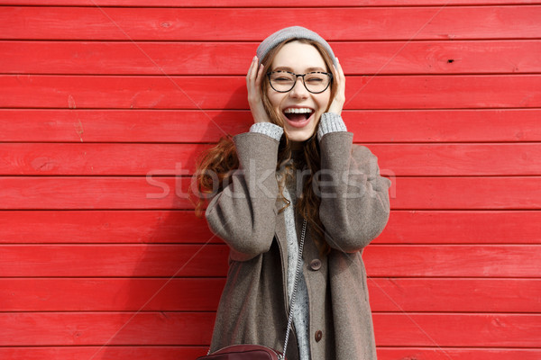 Cheerful pretty young woman standing and laughing Stock photo © deandrobot