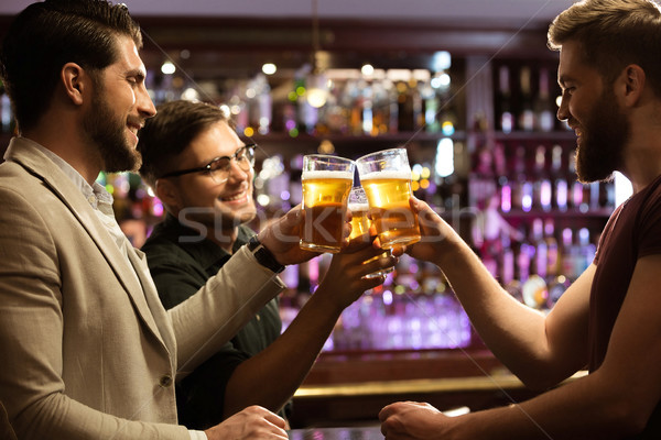 Cheerful young men toasting with beer Stock photo © deandrobot