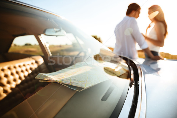 Young couple leaning on a car while standing outdoors Stock photo © deandrobot