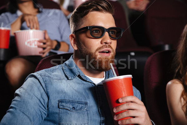 Concentrated young man sitting in cinema Stock photo © deandrobot