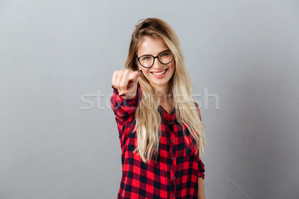 Glimlachend jonge blonde vrouw wijzend foto Stockfoto © deandrobot