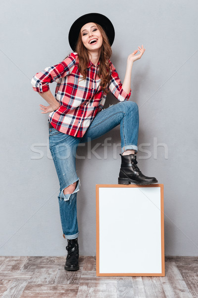 Portrait of a happy smiling young woman in plaid shirt Stock photo © deandrobot