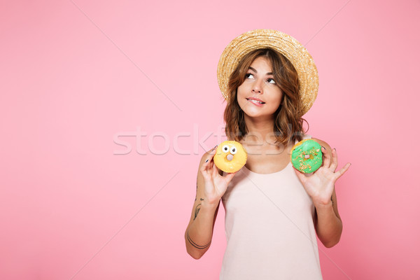 Portrait of a young girl in summer hat holding donuts Stock photo © deandrobot