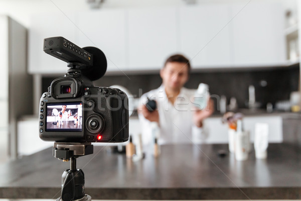 Handsome young man filming his video blog episode Stock photo © deandrobot