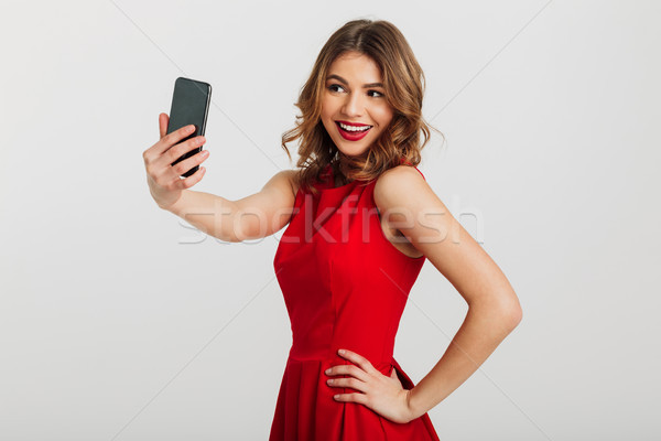 Stock photo: Portrait of a pretty young woman dressed in red dress