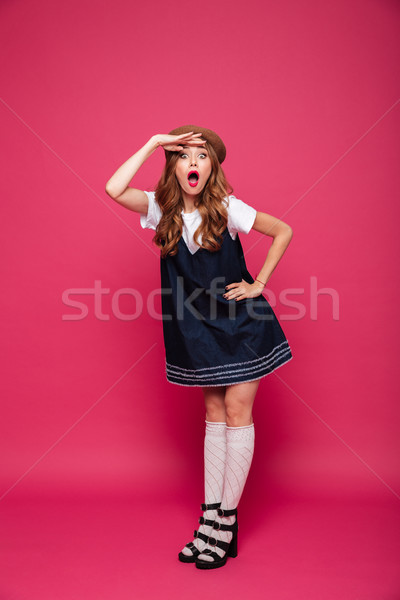 Young funny beautiful lady looking and waiting for somebody isolated over pink Stock photo © deandrobot