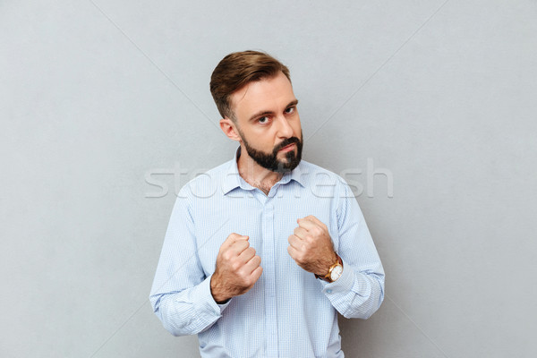 Serious bearded man in business clothes ready to fight Stock photo © deandrobot