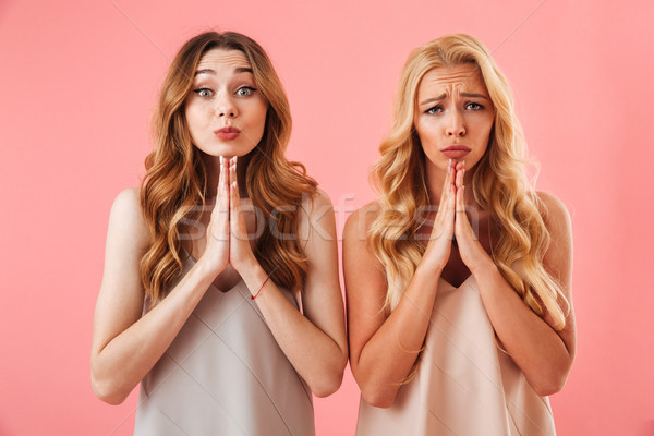 Two worried pretty women in pajamas praying with pray gestures Stock photo © deandrobot
