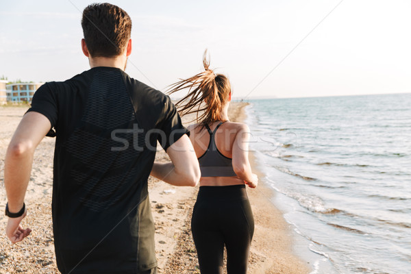 Vedere din spate jogging împreună plajă Imagine de stoc © deandrobot