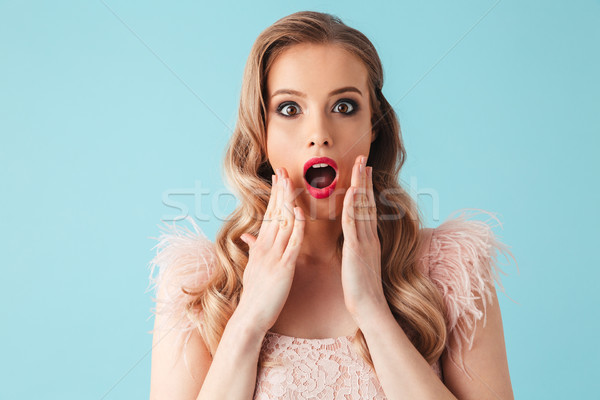 Surprised blonde woman in dress touching her cheeks Stock photo © deandrobot