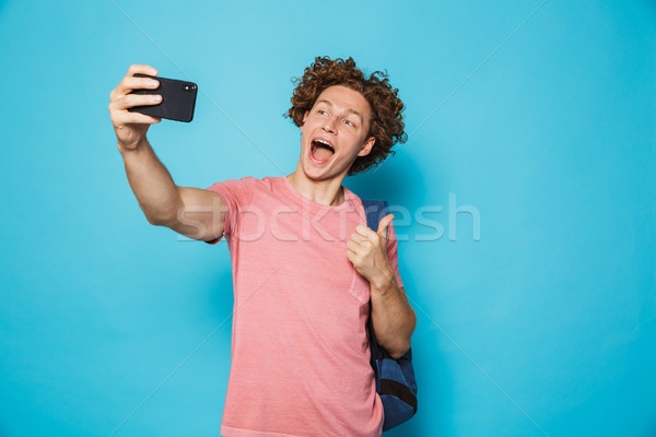 Photo of handsome college guy with curly hair wearing casual clo Stock photo © deandrobot