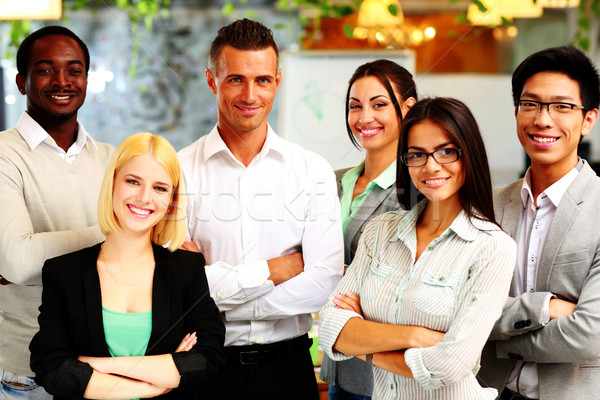Happy group of co-workers standing in office Stock photo © deandrobot