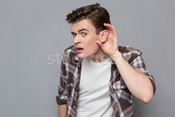 Curious young male trying to listen rumors Stock photo © deandrobot
