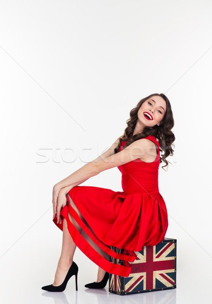 Cute lovely woman sitting on vintage suitcase with british flag Stock photo © deandrobot