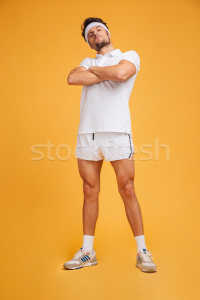 Komoly fiatal sportoló áll keresztbe tett kar citromsárga Stock fotó © deandrobot