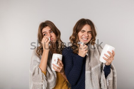 Two happy joking and sad frowning young women drinking tea Stock photo © deandrobot