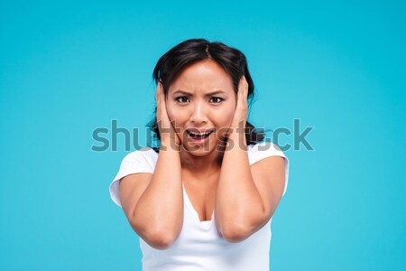 Portrait of a young angry asian woman covering her ears Stock photo © deandrobot