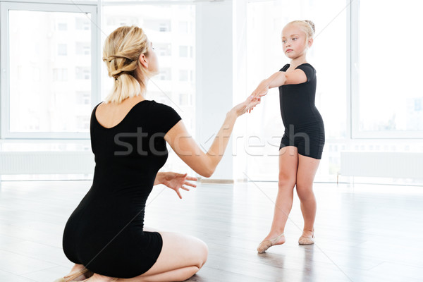 Ballet instructor directing little cute ballerina during dance practice Stock photo © deandrobot