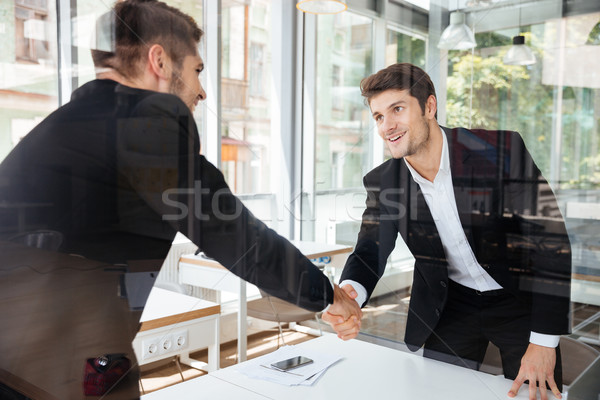 Dos exitoso empresarios pie apretón de manos reunión de negocios Foto stock © deandrobot