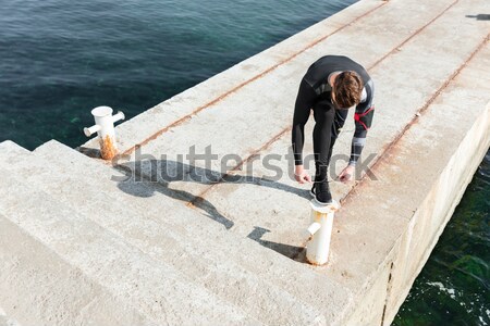 Sportsman warming up near the sea Stock photo © deandrobot