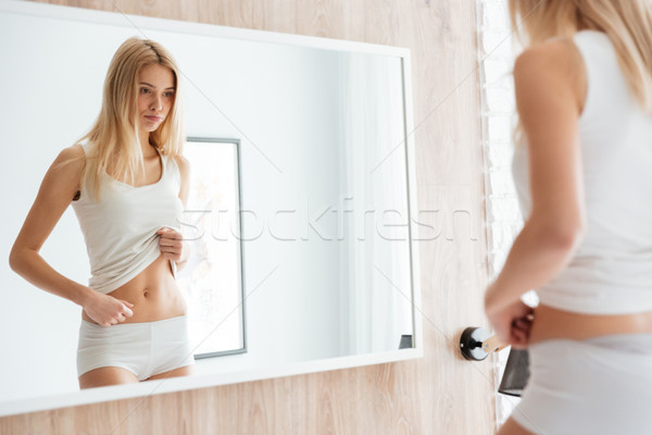 Femeie uita stomac oglindă suparat păr Imagine de stoc © deandrobot