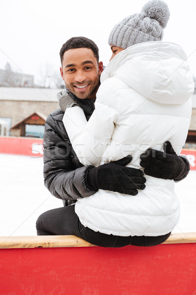Happy loving couple skating at ice rink outdoors. Stock photo © deandrobot