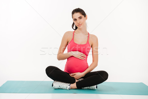 Portrait of a young pregnant woman sitting on the mat Stock photo © deandrobot